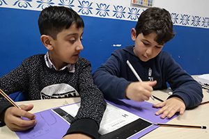 Dos nens migrats atenent a les classes impartides per Bayt-Al-Thaqafa